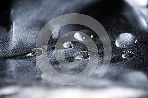 Crystal clear water drops on a silvery fabric